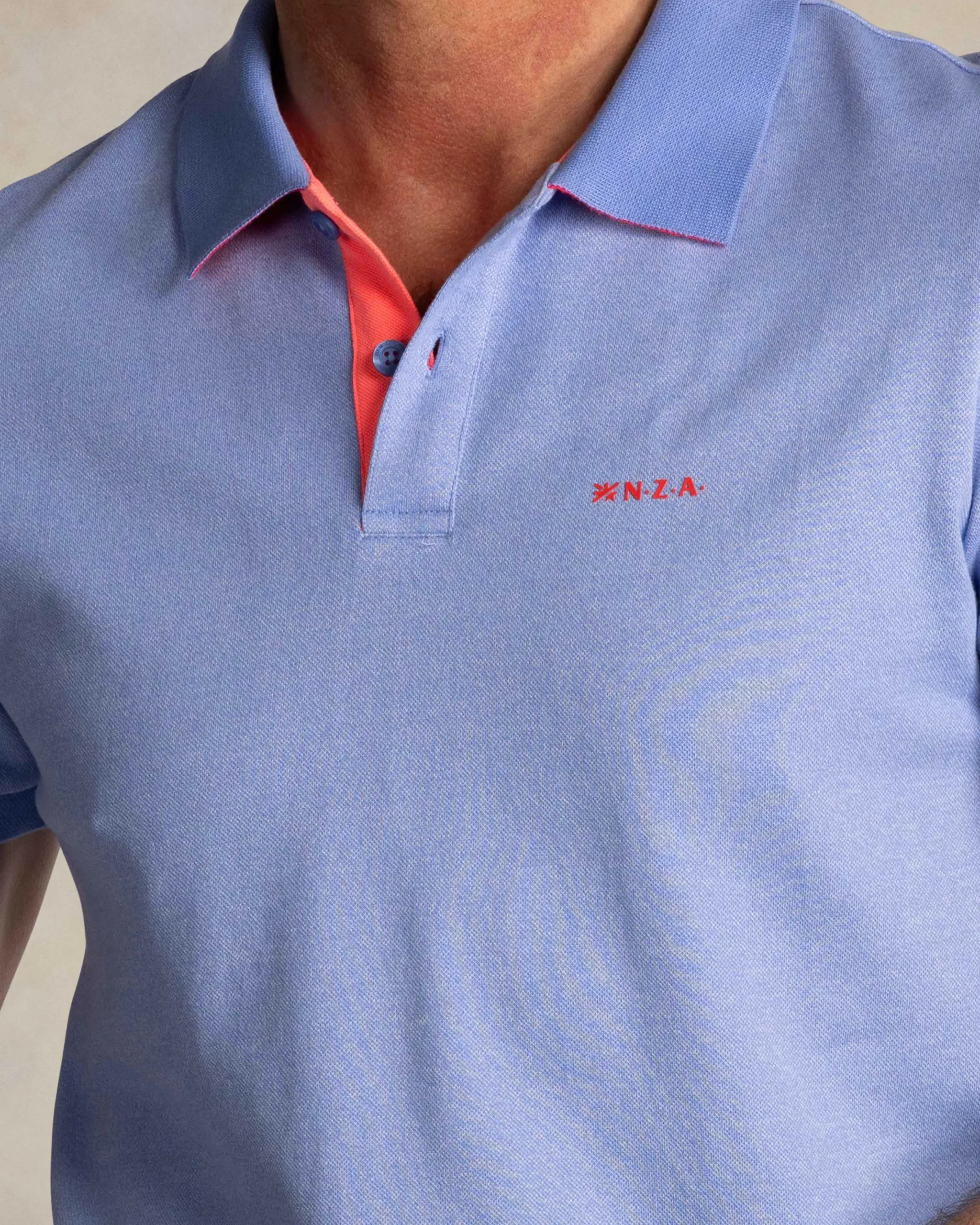 NZA New Zealand Auckland Effen lichtblauwe polo met oranje details